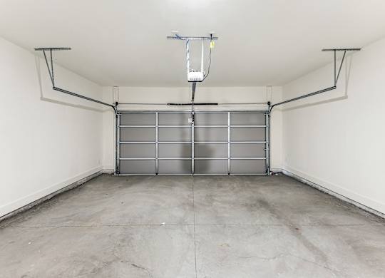 the inside of a garage with white walls and a concrete floor