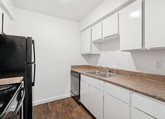 A kitchen with white cabinets and a granite countertop.