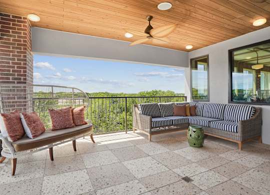 A patio with a couch, chair, and table.
