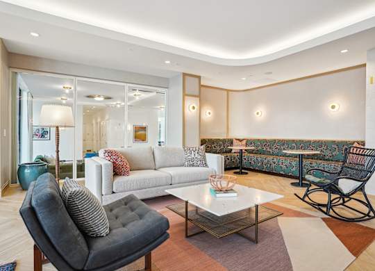 A living room with a grey chair and a white couch.