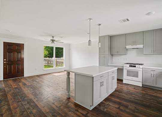 A kitchen with white appliances and wooden floors.