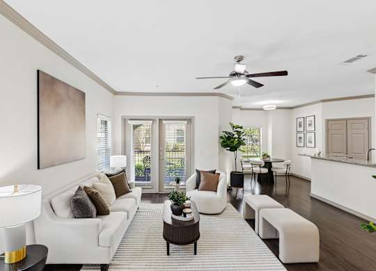 A living room with a white couch and a painting on the wall.