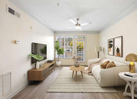 A living room with a white couch, a wooden coffee table, and a flat-screen TV mounted on the wall.