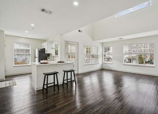 A spacious kitchen with a bar area and wooden flooring.