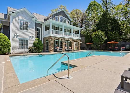 A large house with a pool in front.