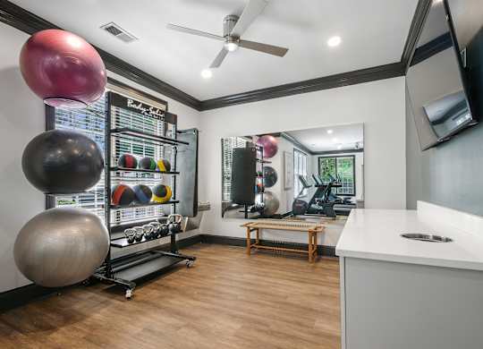 A gym room with a variety of exercise equipment.