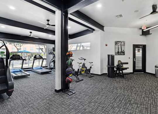 A gym with treadmills, exercise bikes, and weights.