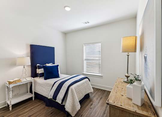 a bedroom with a bed and a dresser and a window