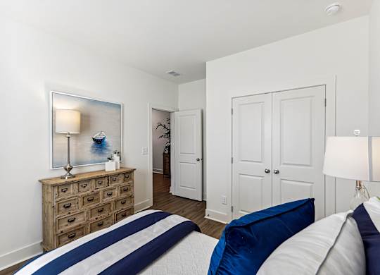 a bedroom with a bed and a dresser     and a hallway