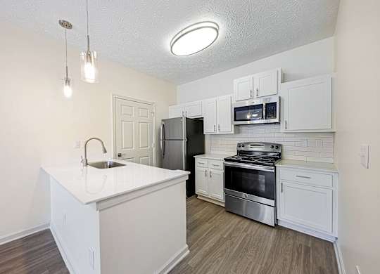 A kitchen with white cabinets and stainless steel appliances.