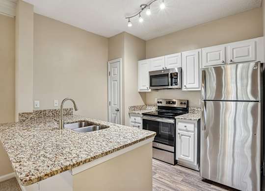 A kitchen with granite countertops and stainless steel appliances.