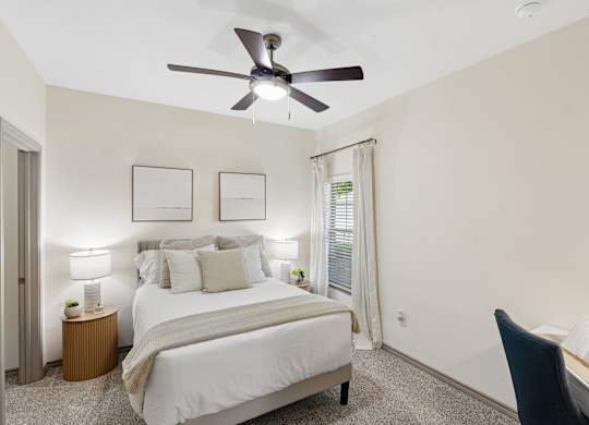 A bedroom with a bed, desk, and chair.