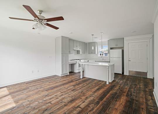 A kitchen with a white counter and a white fridge.