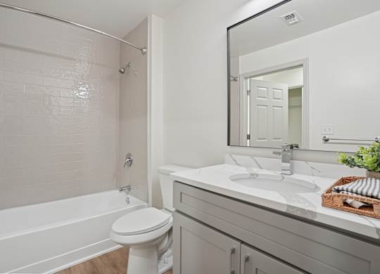 A white bathroom with a toilet, sink, and bathtub.
