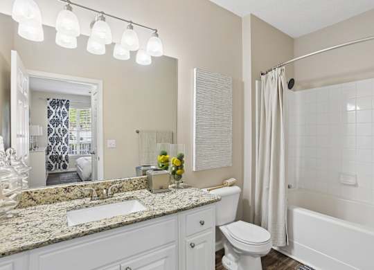 A bathroom with a white toilet, sink, and bathtub.