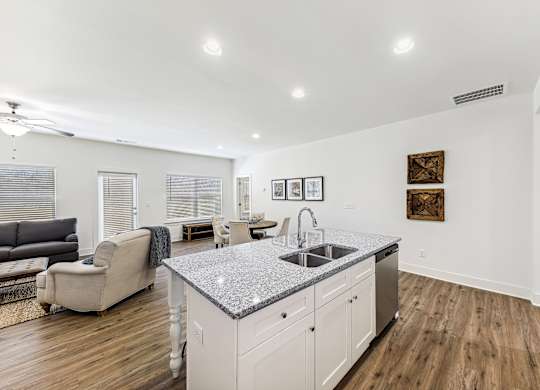 A kitchen with a granite countertop and white cabinets.