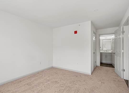 A room with a red square on the wall and carpet on the floor.