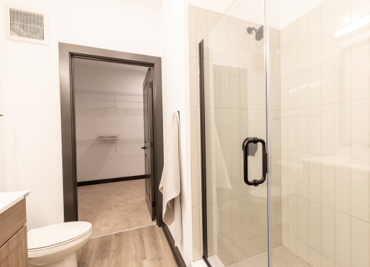 a bathroom with a white toilet next to a glass shower door