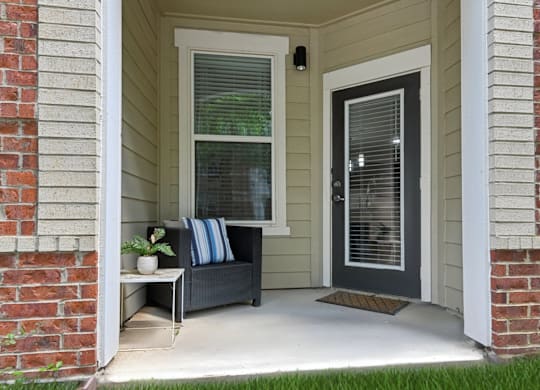 A house entrance with a bench and a door.