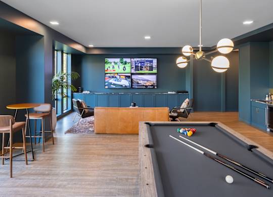 A room with a pool table and a television.