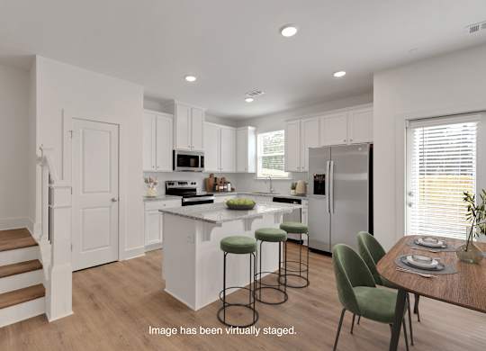 A kitchen with white cabinets and a white fridge.