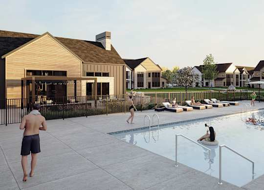 A group of people are enjoying a swimming pool in front of a house.