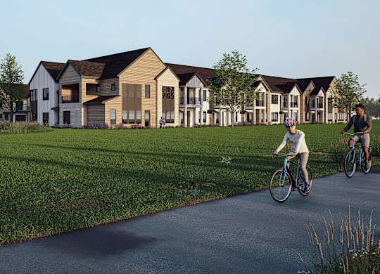 A person riding a bicycle on a path in front of a row of houses.