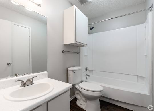 A white bathroom with a sink, toilet and bathtub.