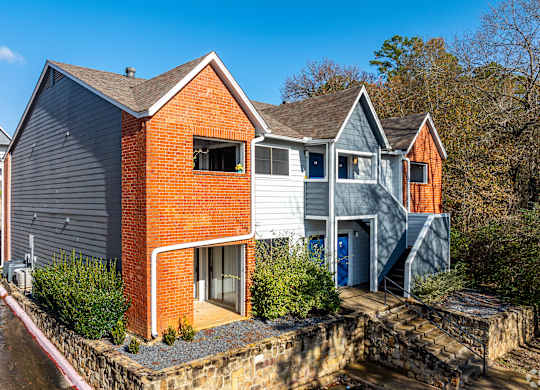 A modern house with a red brick facade and a grey roof.