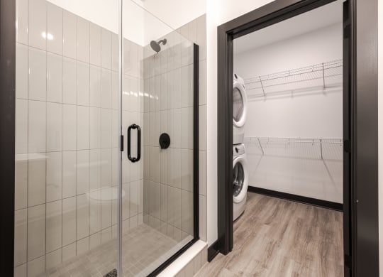 a bathroom with a shower and a washing machine in it