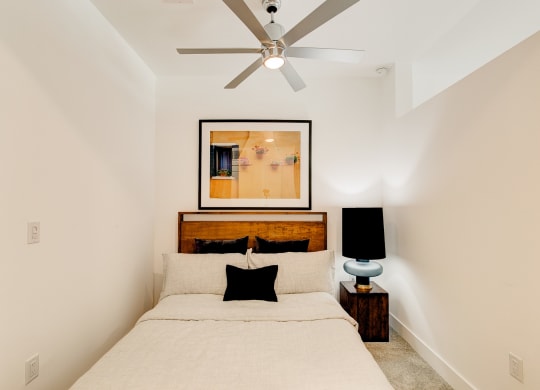 a bedroom with a bed and a ceiling fan