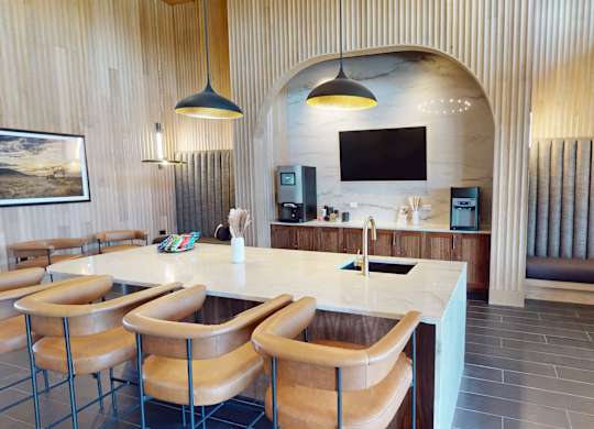 A modern kitchen with a bar area and a couch.