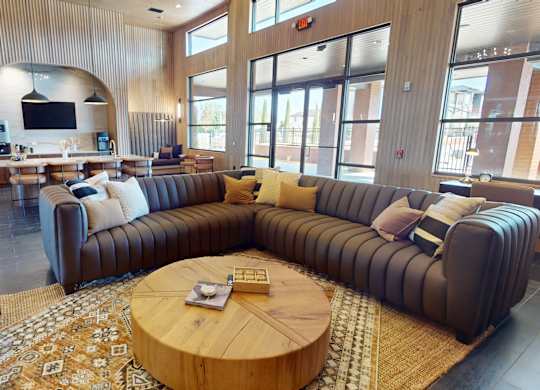 A living room with a large couch and a TV mounted on the wall.