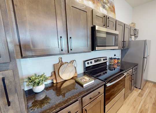 A kitchen with stainless steel appliances and wooden cabinets.
