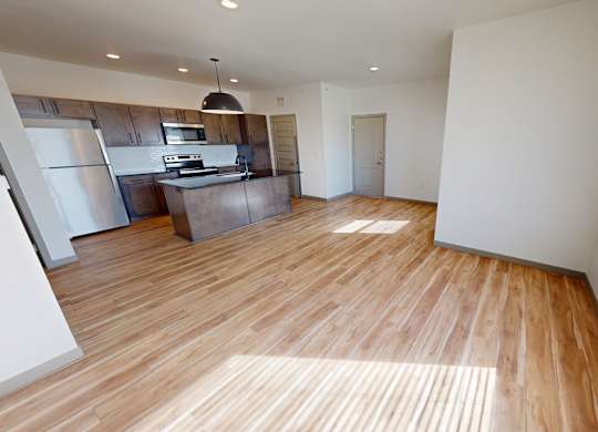 A kitchen with wooden floors and a refrigerator.