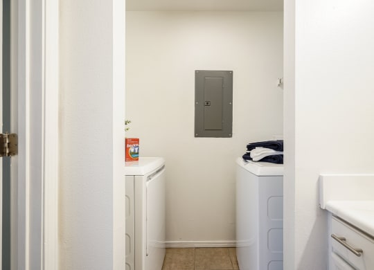 a laundry room with two washers and two dryers