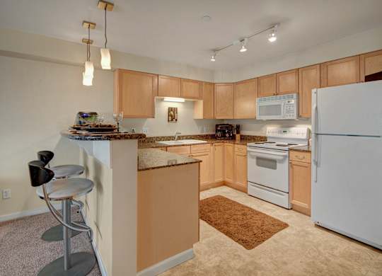A kitchen with white appliances and wooden cabinets.