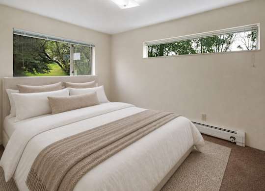 A bedroom with a large bed and a window.