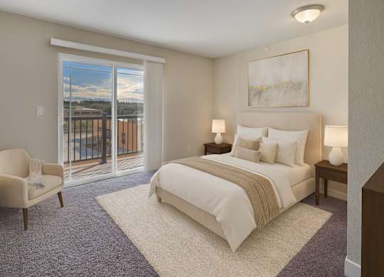 A bedroom with a large bed and a chair by a window.