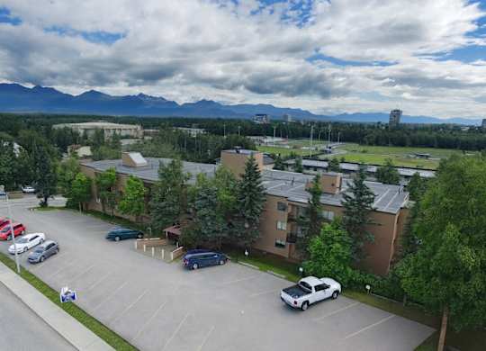 A parking lot with cars and a mountain range in the background.