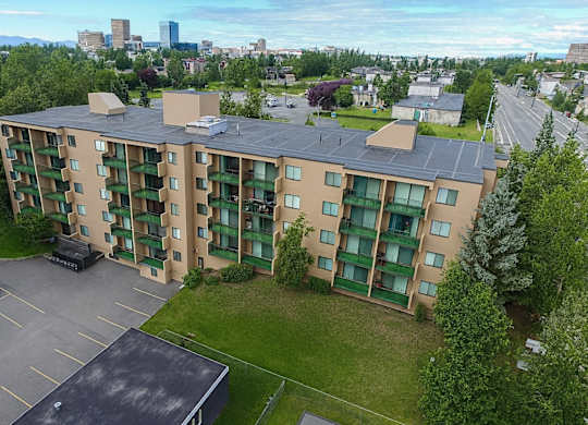 A large apartment complex with a parking lot in front.