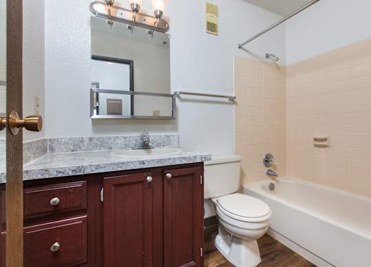 A bathroom with a toilet, sink, and bathtub.