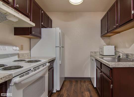 A kitchen with brown cabinets and a white refrigerator.