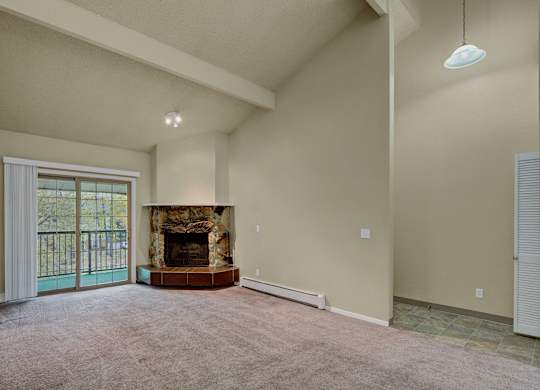 A living room with a fireplace and sliding glass doors.