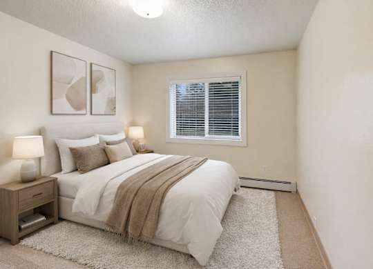 A bedroom with a bed, nightstand, and two framed pictures on the wall.