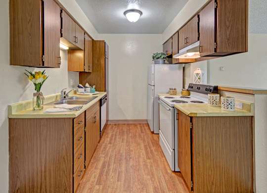 A kitchen with wooden cabinets and a white refrigerator.