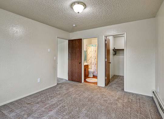 A room with a carpeted floor and a doorway leading to another room.