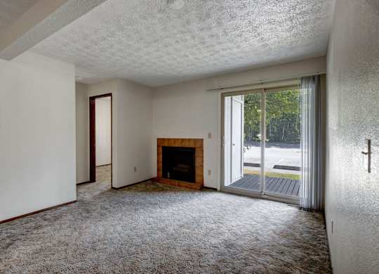 A room with a fireplace and sliding glass doors.