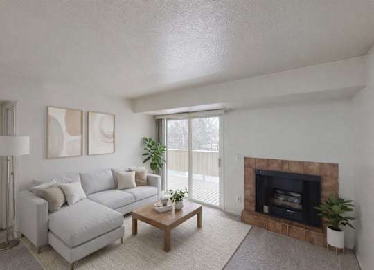 A living room with a grey couch, a fireplace, and a plant.