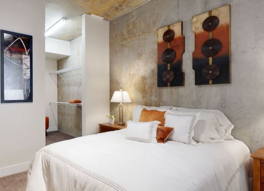 a bedroom with a bed and three paintings on the wall